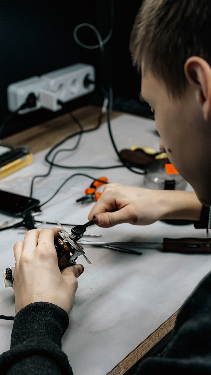 Home A young technician working meticulously on electronic repairs at a workstation.